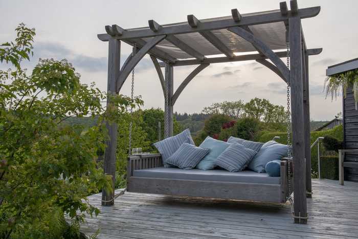 Swinging Day Bed with pergola at dusk in garden