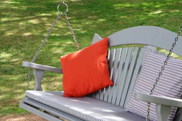 Close up of swinging bench with bright colour cushions