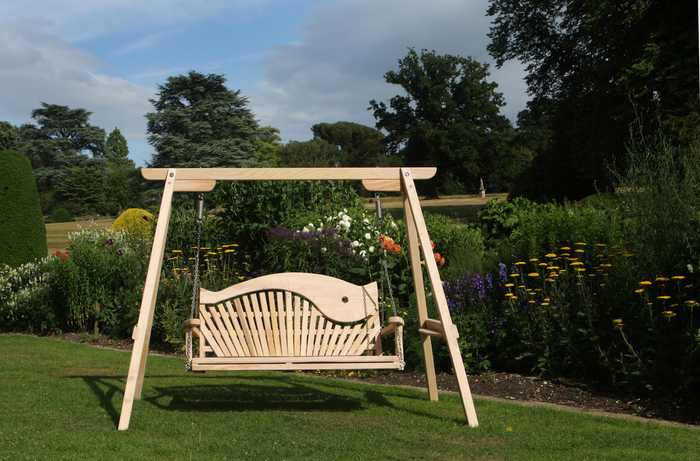 3 seater swing seat on lawn with beautiful flower beds behind