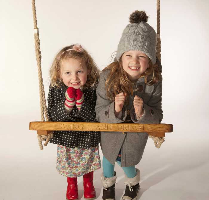 Two young girls enjoying oak rope swing