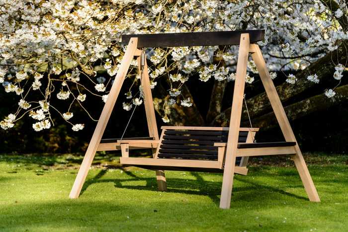 Modern swing seat with spring bloom behind 