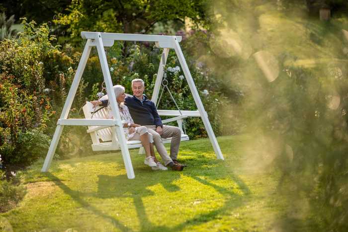 Couple enjoying painted garden swing seat 