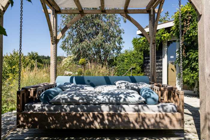 Day bed with beverage holders on the inside, and cushions flattened in the centre