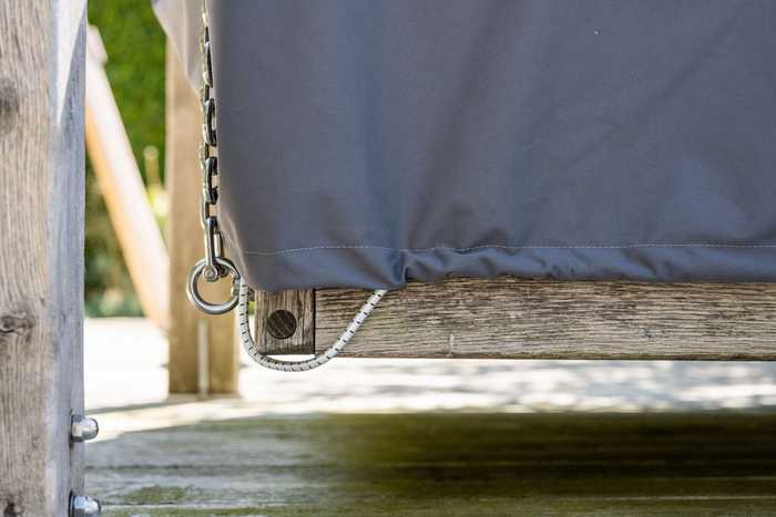 Close up of chord wrapped underneath corner of wooden day bed frame