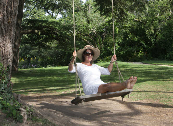 woman in a hat swinging on a Two-seat Oak Rope Swing