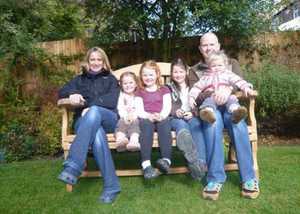 Happy family sitting on a large garden bench