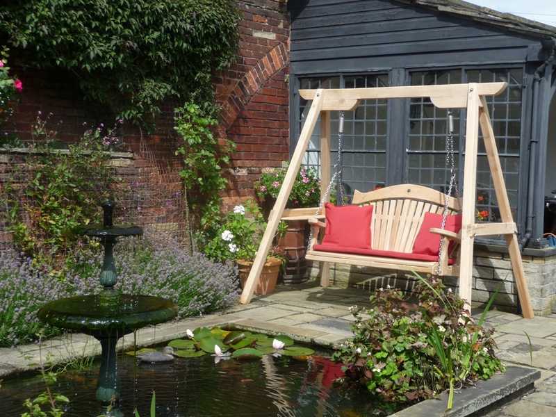 Swing seat in a garden with a pond