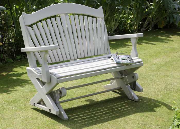 A rocking bench on a lawn with book
