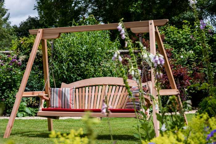 3 seater wooden swing seat with a cushion set in garden
