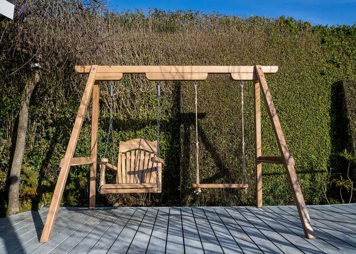 Wooden swings hanging from frame on decking