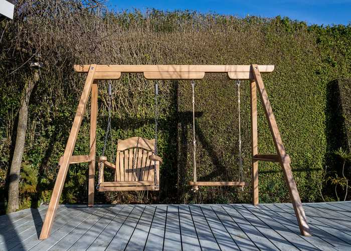 Wooden swings hanging from frame on decking Wooden swings hanging from frame on decking