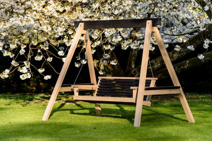 Modern swing seat with spring bloom behind Modern swing seat with spring bloom behind