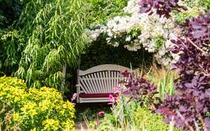 Zoomed out on Serenity 3 Seat Swing in a garden