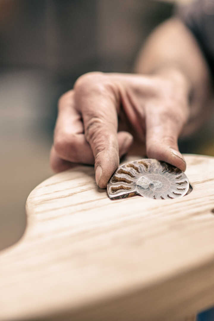An inset ammonite being placed in the swing seat arm