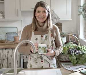 Ann-Marie holding a watering can ready to garden in some colourful heels