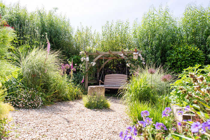 A pergola with a swing in the Sitting Spiritually garden in Lyme Regis