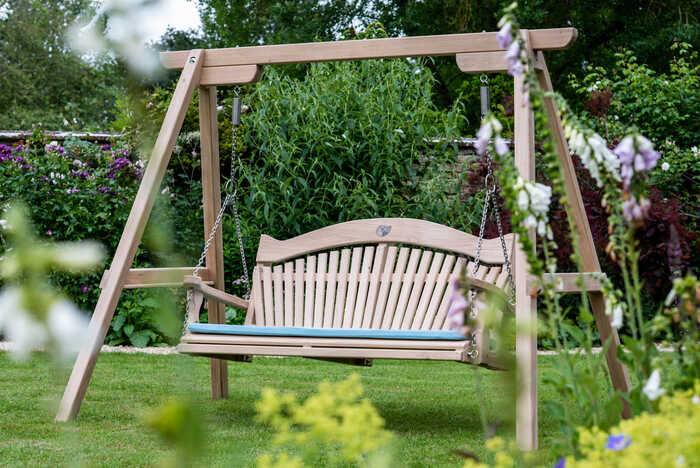Garden swing seat situated over green hills and grass